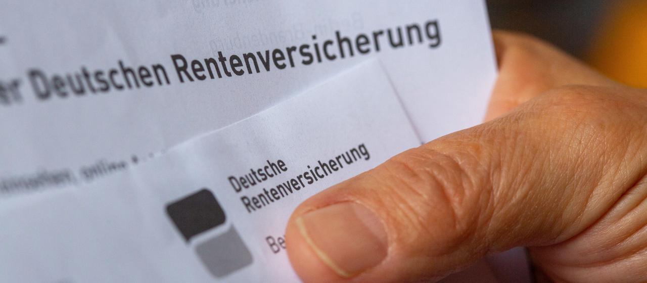 Eine Seniorin hält ein Schreiben der Deutschen Rentenversicherung in der Hand.