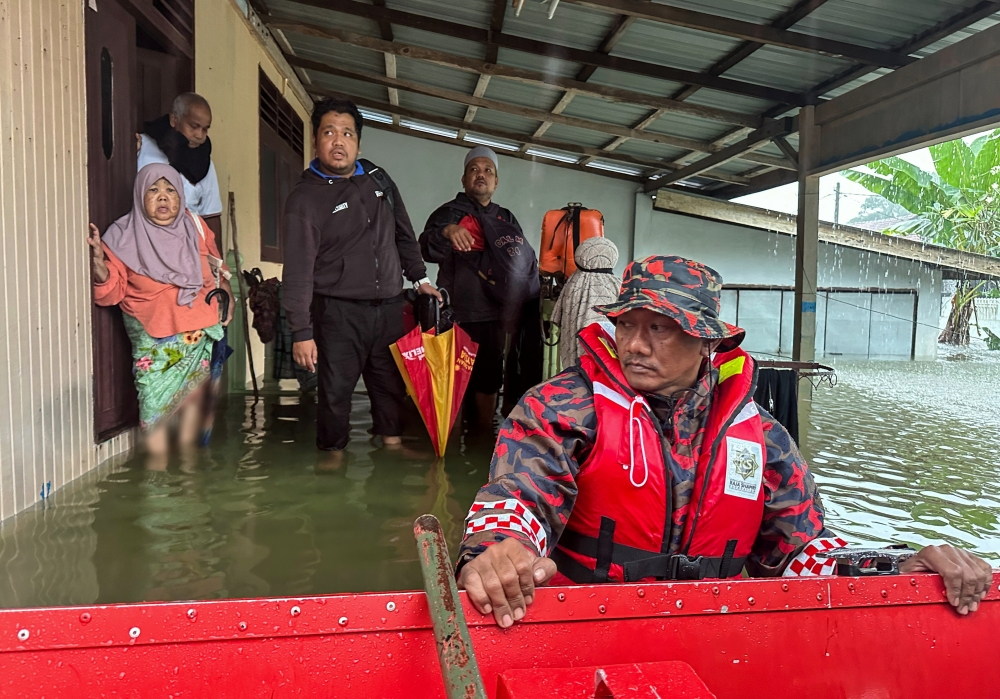 File picture of Kelantan Fire and Rescue Department personnel assisting residents of Kampung Lati trapped by rapid and severe floods near in Pasir Mas, on November 29, 2024. — Bernama pic