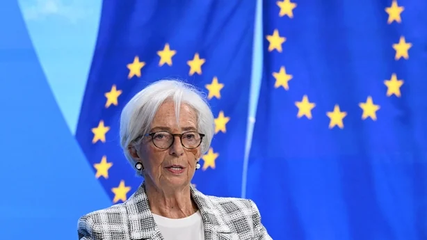 A business woman talks on a stage with European Union flags in the background