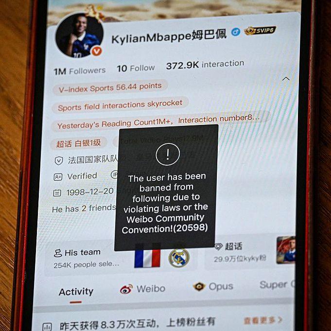 This photo illustration shows French football star Kylian Mbappe's Chinese social media Weibo account displaying the message: "The user has been banned from following due to violating laws of the Weibo Community Convention".